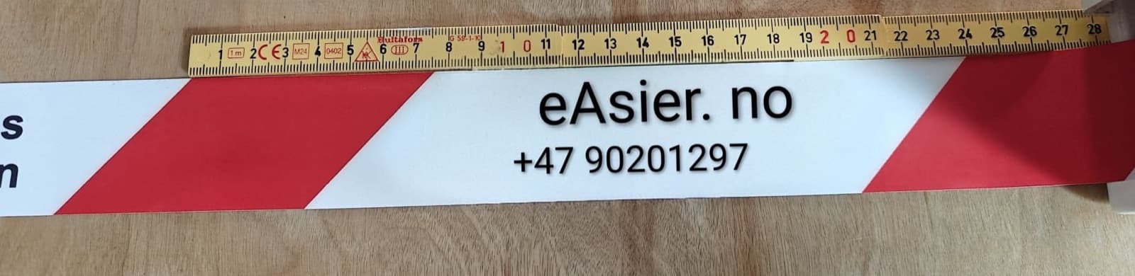 Sperrebånd i rød/hvit med kundens egen tekst trykt i det hvite feltet, målt med tommestokk
